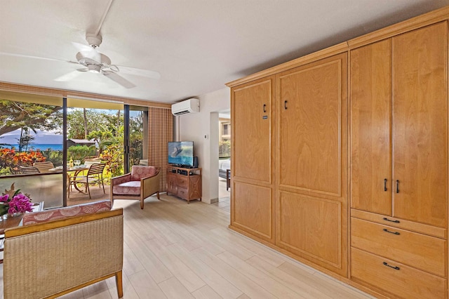 4327 Lower Honoapiilani Rd Unit 101B, Lahaina, HI 96761 - sitting room with a wall mounted AC, ceiling fan, a wall of windows, and light wood-type flooring