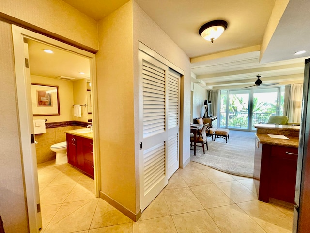 hallway featuring sink and light tile patterned flooring