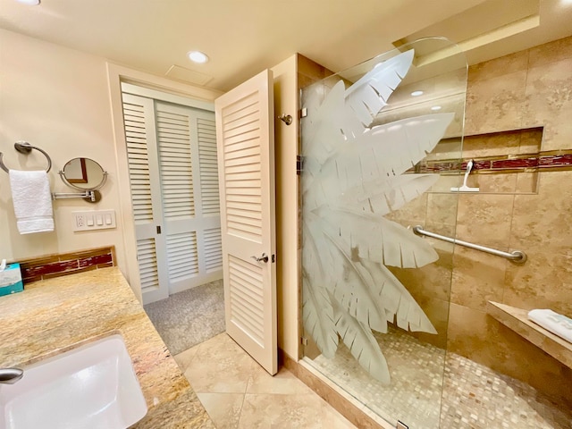 bathroom featuring tile patterned flooring, an enclosed shower, and vanity