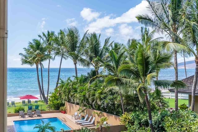 view of swimming pool with a patio area and a water view