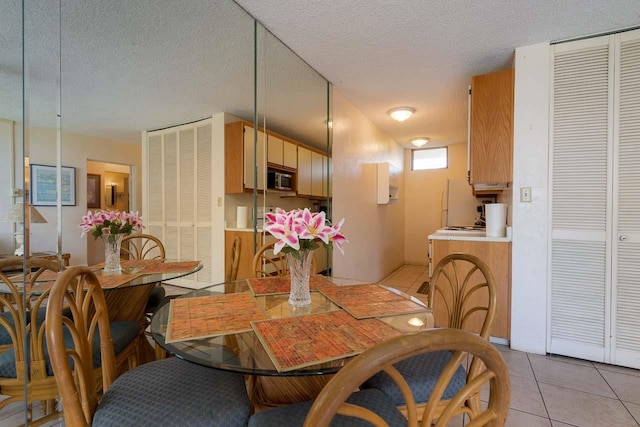 tiled dining room with a textured ceiling