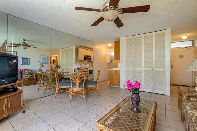 dining room featuring a textured ceiling, ceiling fan, and light tile patterned floors