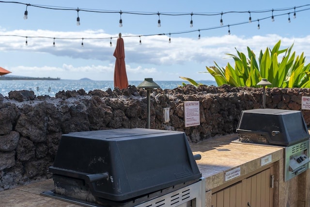 view of patio / terrace featuring a water view and grilling area