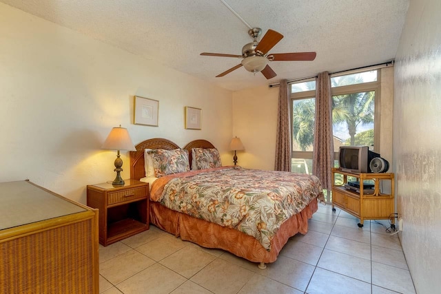 bedroom featuring a textured ceiling, ceiling fan, and light tile patterned floors