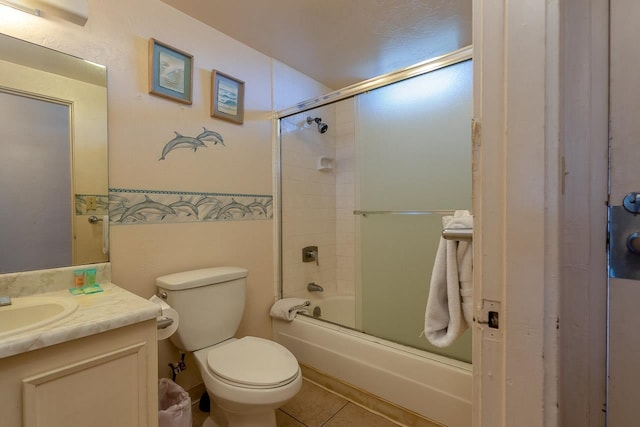 full bathroom featuring shower / bath combination with glass door, tile patterned floors, vanity, and toilet