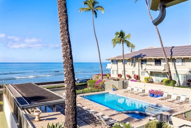 view of swimming pool with a water view and a patio