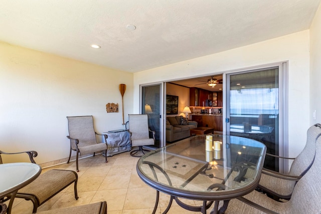 interior space with light tile patterned floors, a textured ceiling, and ceiling fan