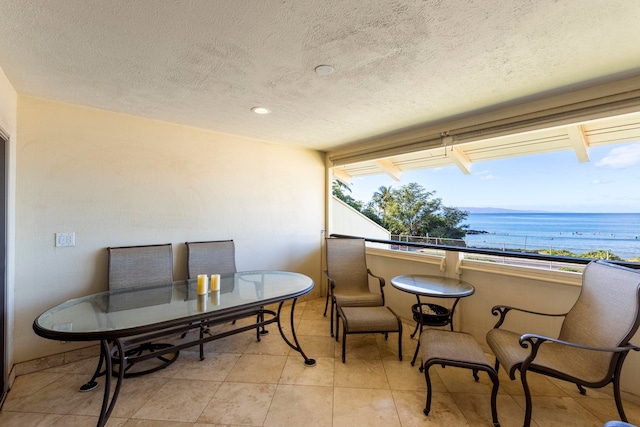 balcony featuring a view of the beach and a water view