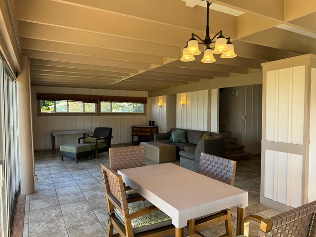 tiled dining room with a chandelier and beam ceiling