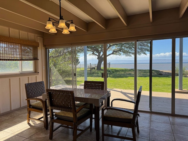 sunroom / solarium with an inviting chandelier, a water view, and beamed ceiling