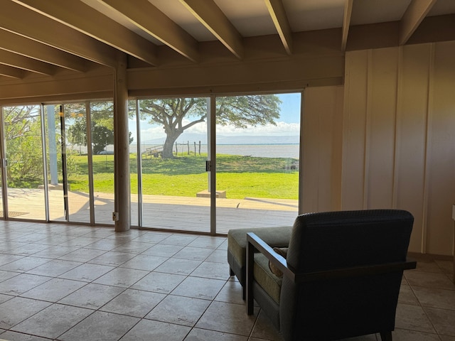 interior space with beamed ceiling and a water view