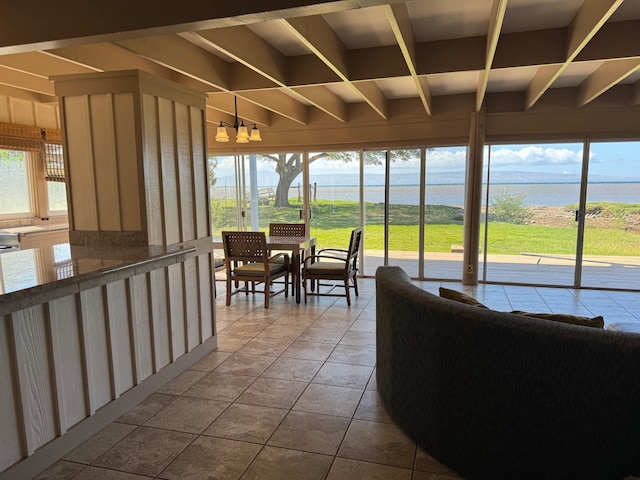 sunroom featuring a water view and a notable chandelier