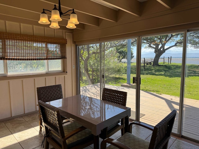 sunroom with a water view and a chandelier