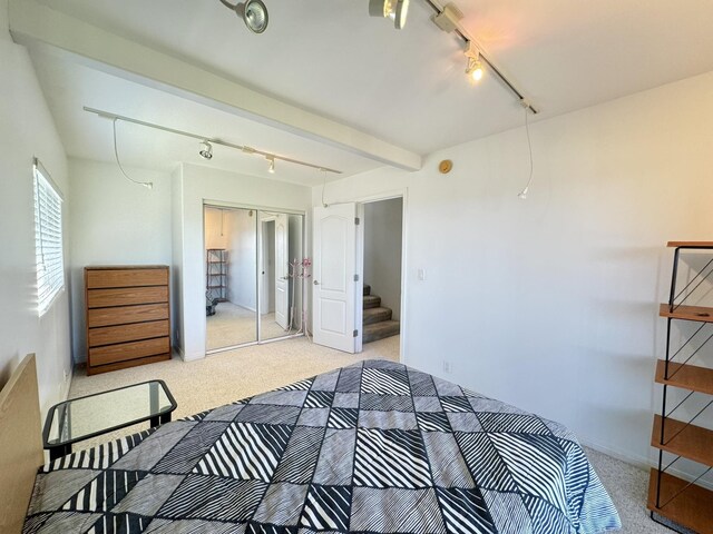 bedroom featuring beam ceiling and carpet