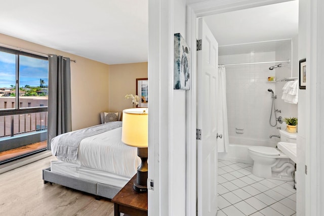 bedroom featuring connected bathroom, light tile patterned floors, and access to exterior