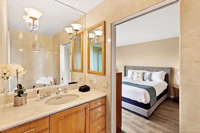 bathroom with wood-type flooring, vanity, and a notable chandelier