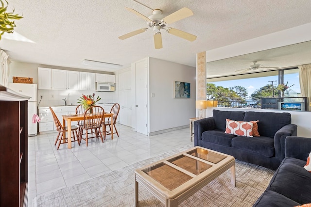 tiled living room featuring a textured ceiling and ceiling fan