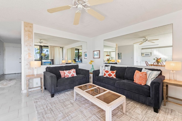 living room featuring ceiling fan, light tile patterned floors, and a textured ceiling