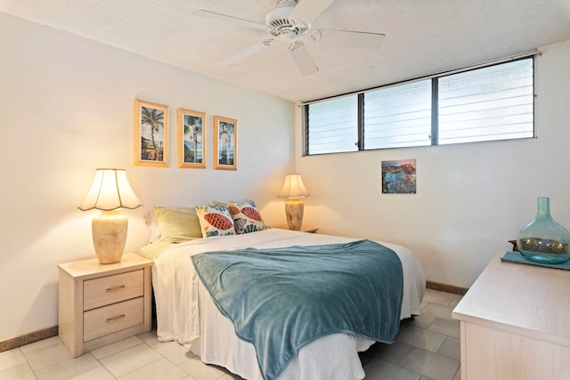 tiled bedroom featuring ceiling fan and a textured ceiling