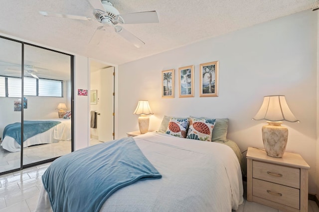 tiled bedroom featuring ceiling fan, a closet, and a textured ceiling