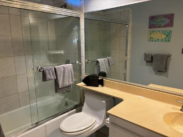 full bathroom featuring shower / bath combination with glass door, vanity, and toilet