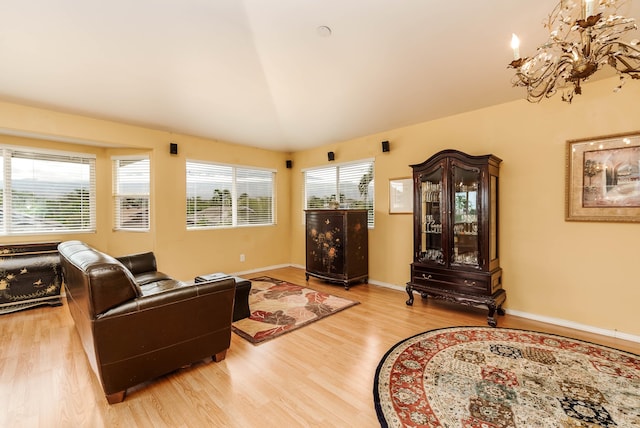 living room with vaulted ceiling, light hardwood / wood-style floors, and a wealth of natural light