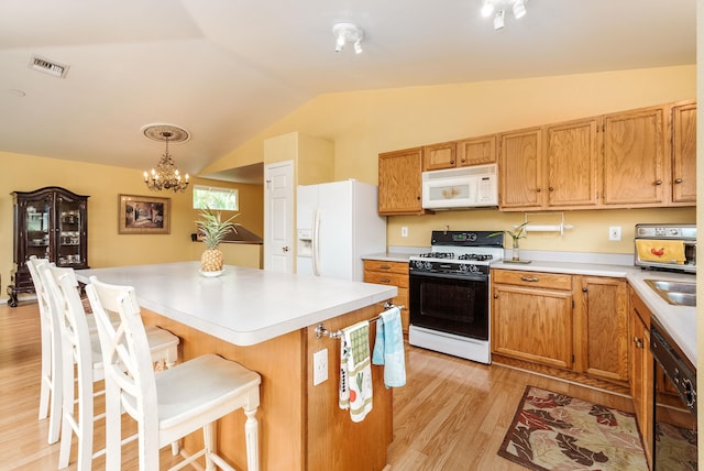 kitchen with a notable chandelier, vaulted ceiling, hanging light fixtures, light hardwood / wood-style flooring, and white appliances