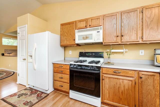 kitchen featuring light hardwood / wood-style flooring, white appliances, vaulted ceiling, and light brown cabinetry