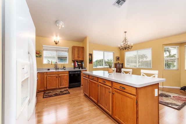 kitchen with pendant lighting, white fridge with ice dispenser, black dishwasher, a center island, and light hardwood / wood-style flooring