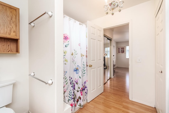 bathroom featuring a shower with shower curtain, hardwood / wood-style flooring, and toilet