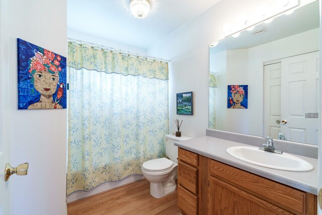 full bathroom featuring shower / tub combo, wood-type flooring, vanity, and toilet