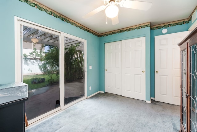 unfurnished bedroom featuring access to outside, ceiling fan, and light colored carpet