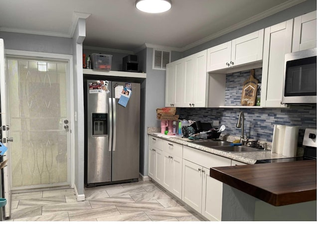 kitchen featuring visible vents, ornamental molding, tasteful backsplash, appliances with stainless steel finishes, and a sink