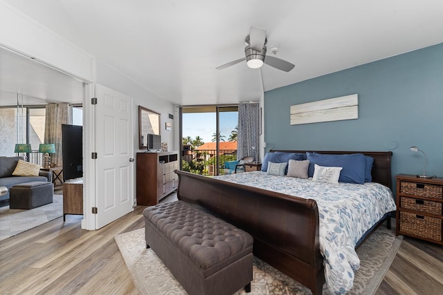 bedroom with ceiling fan, multiple windows, and wood-type flooring