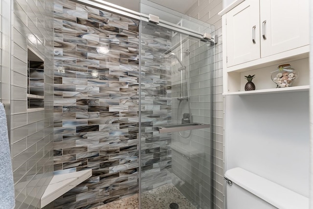 bathroom with toilet and an enclosed shower