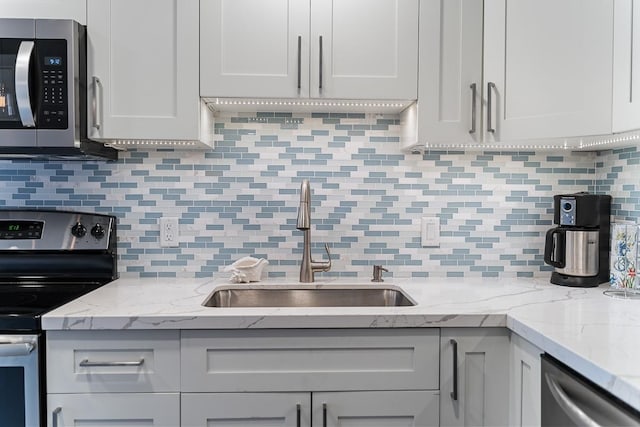 kitchen featuring appliances with stainless steel finishes, tasteful backsplash, and light stone counters