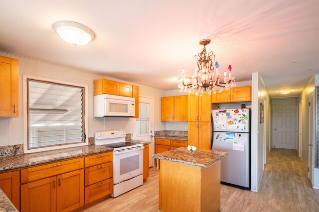 250 Kahiko St, Paia, HI 96779 - kitchen with white appliances, a kitchen island, light wood-style floors, stone counters, and a chandelier