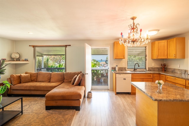 250 Kahiko St, Paia, HI 96779 - kitchen featuring white dishwasher, a sink, open floor plan, a chandelier, and light stone counters