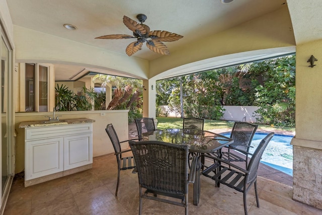 view of patio with ceiling fan and sink