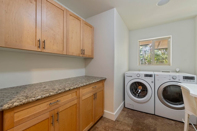 clothes washing area with washing machine and clothes dryer and cabinets