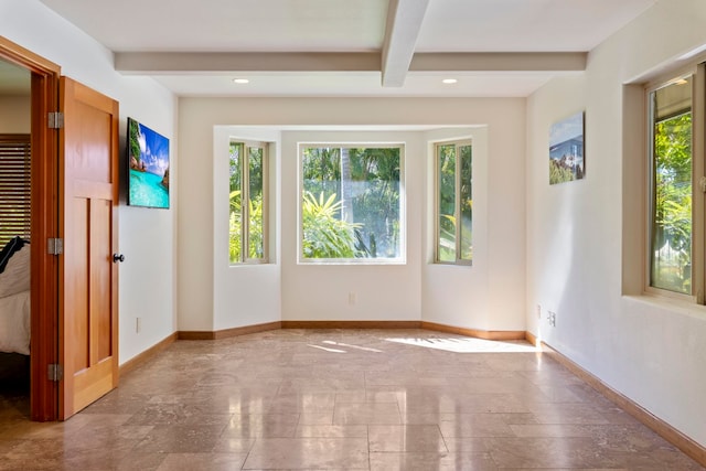 spare room with beamed ceiling