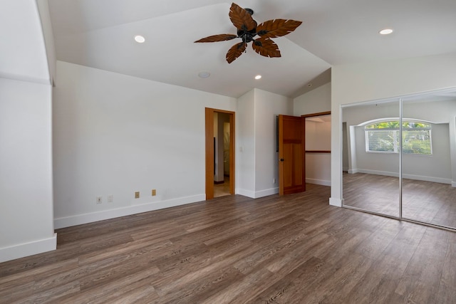 unfurnished bedroom with a closet, vaulted ceiling, ceiling fan, and dark hardwood / wood-style floors