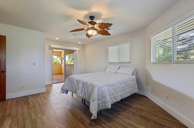 bedroom with dark hardwood / wood-style flooring and ceiling fan