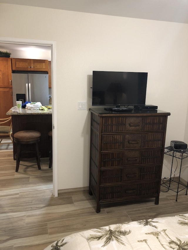 interior details featuring hardwood / wood-style flooring and stainless steel fridge with ice dispenser