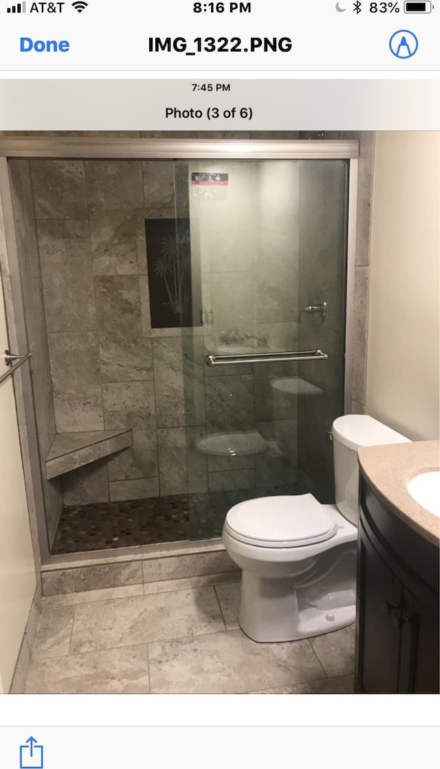 bathroom featuring vanity, an enclosed shower, and toilet