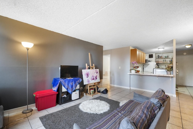 living area with baseboards, a textured ceiling, and light tile patterned flooring