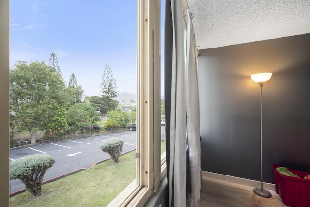 room details featuring a textured ceiling, parking, and baseboards