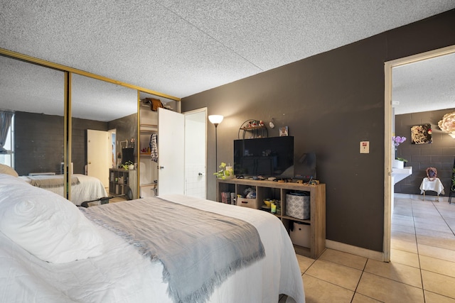 bedroom with light tile patterned flooring, a closet, and a textured ceiling