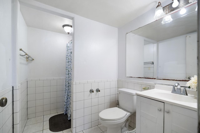 full bathroom featuring tile walls, toilet, wainscoting, tile patterned floors, and vanity