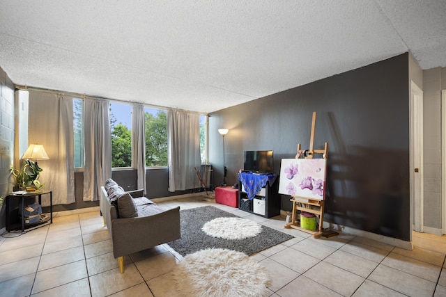 tiled living area featuring baseboards and a textured ceiling